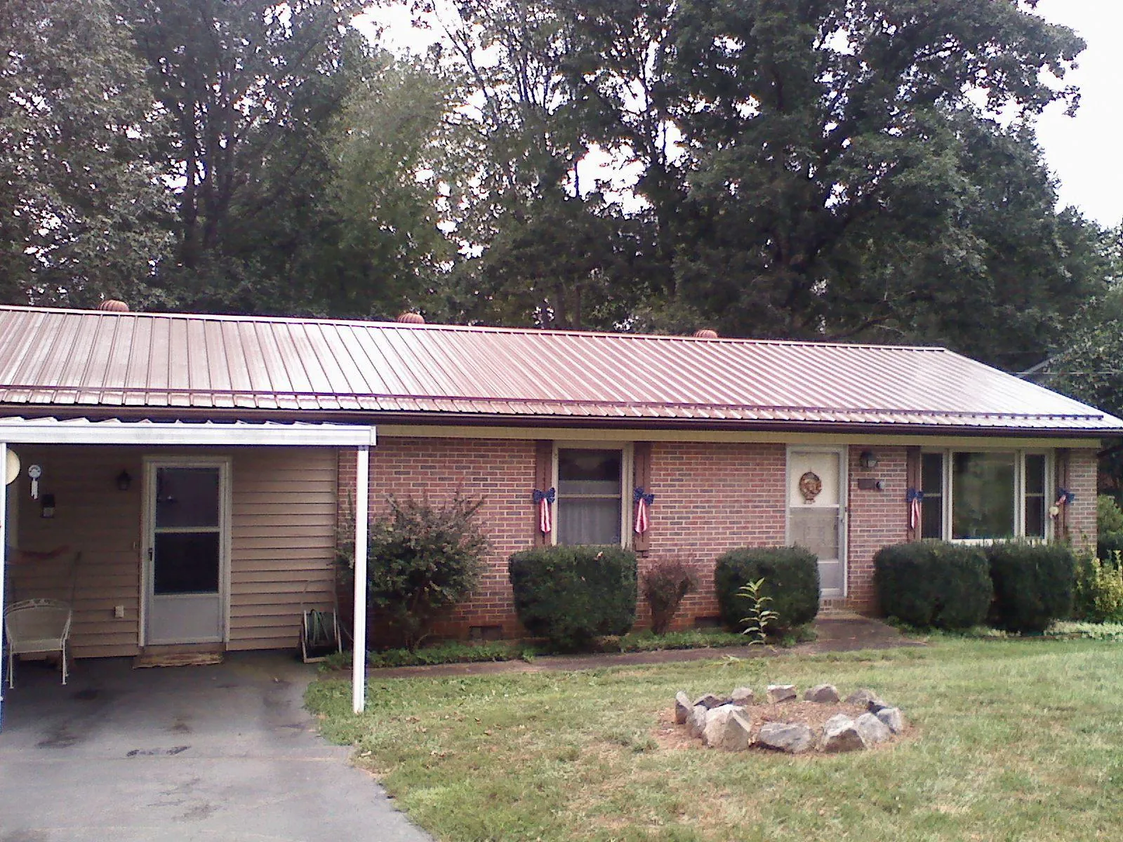 Bronze metal roof and carport on a brick ranch home — Roof Repair work by our crew in Metairie