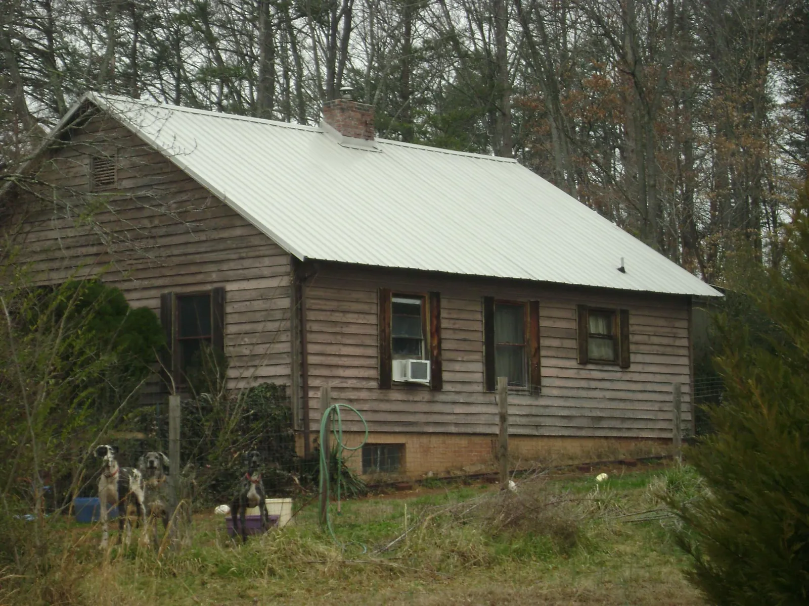 White metal roof on an old wood sided farmhouse, from a Asphalt Shingle Roof Repair job in Metairie